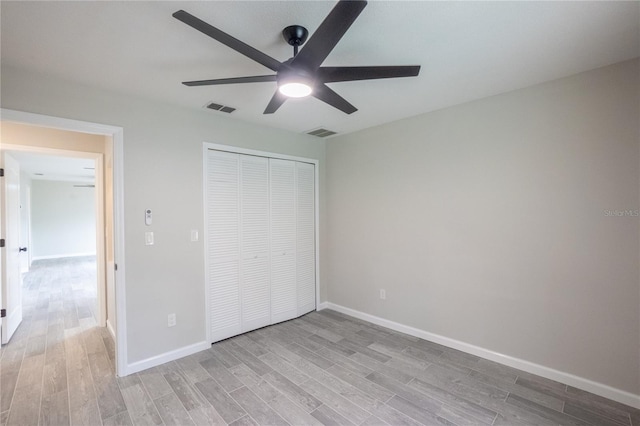 unfurnished bedroom with baseboards, a closet, visible vents, and light wood-style floors