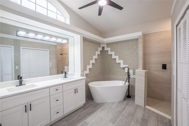 full bath featuring a walk in shower, vaulted ceiling, a closet, and a sink