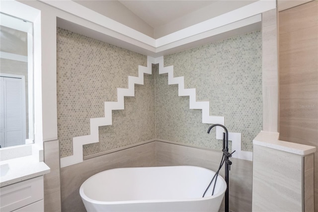 full bathroom featuring a soaking tub and vanity