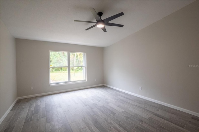 unfurnished room featuring ceiling fan, baseboards, and wood finished floors