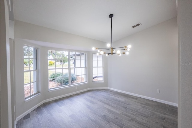 empty room with an inviting chandelier, baseboards, visible vents, and dark wood-style flooring