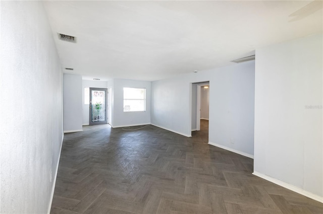 spare room featuring dark parquet flooring