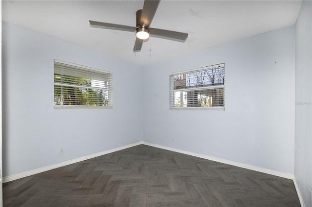 unfurnished room featuring ceiling fan and dark parquet flooring