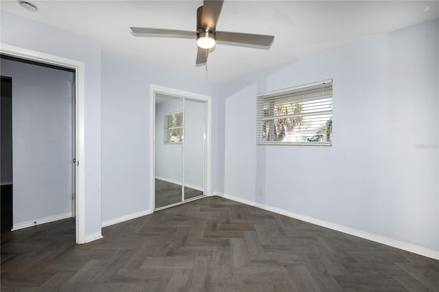 unfurnished bedroom featuring ceiling fan and dark parquet flooring