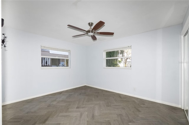 spare room featuring dark parquet floors and ceiling fan