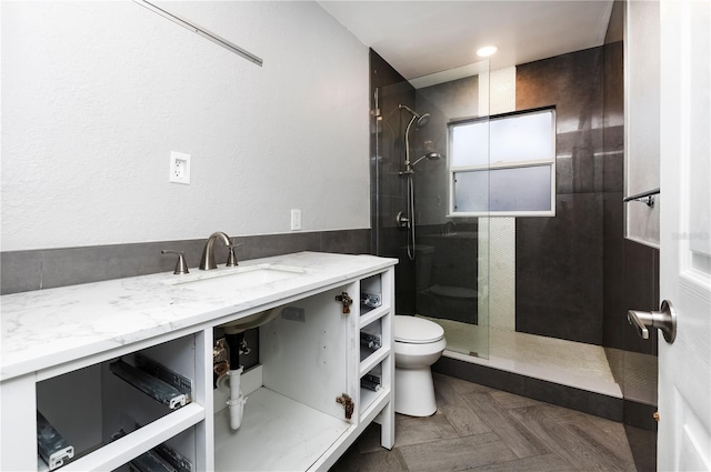 bathroom with sink, toilet, and tiled shower