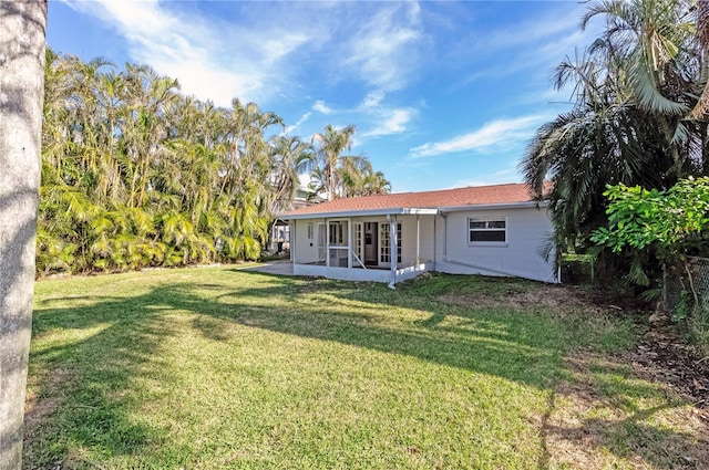 back of house with a patio area and a yard