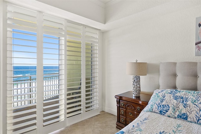 bedroom featuring a water view and light tile patterned floors