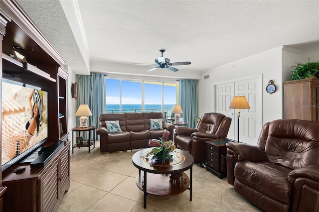 tiled living room featuring ceiling fan, a water view, crown molding, and a textured ceiling