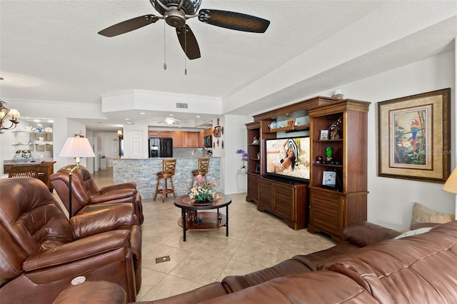 tiled living room featuring crown molding, ceiling fan with notable chandelier, and a textured ceiling