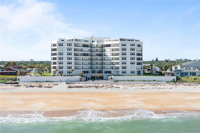 view of property with a water view and a view of the beach