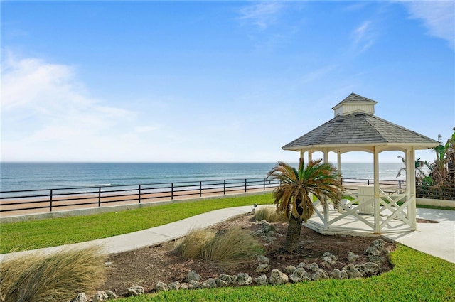 exterior space with a gazebo, a water view, and a view of the beach