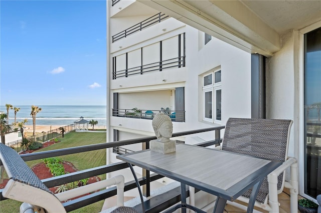 balcony featuring a water view and a beach view