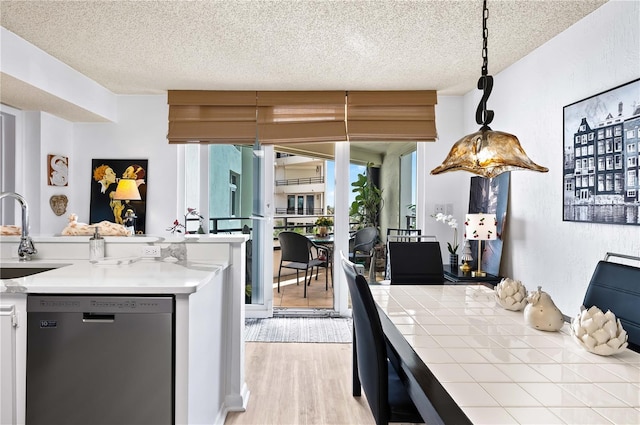 kitchen featuring pendant lighting, sink, a textured ceiling, and black dishwasher