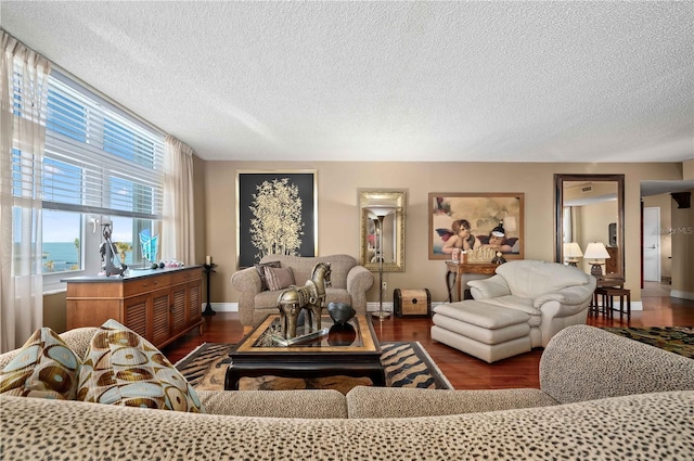 living room with a water view, dark hardwood / wood-style floors, and a textured ceiling