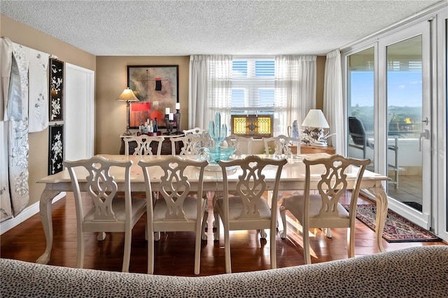 dining area with wood-type flooring and a textured ceiling