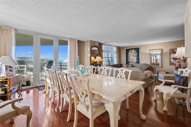 dining area featuring hardwood / wood-style flooring, a textured ceiling, and a wall of windows