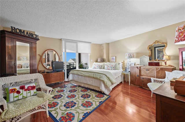 bedroom with hardwood / wood-style floors and a textured ceiling