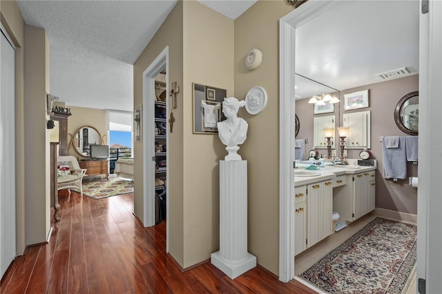 bathroom featuring hardwood / wood-style flooring, vanity, and a textured ceiling