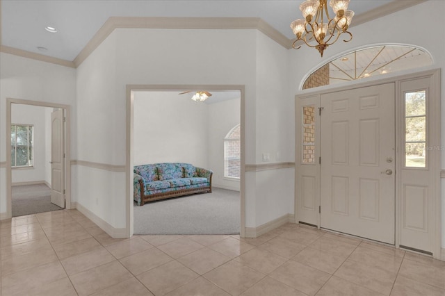 foyer featuring crown molding, light colored carpet, and a healthy amount of sunlight