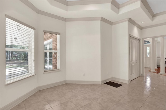 spare room with ornate columns, light tile patterned flooring, crown molding, and a tray ceiling