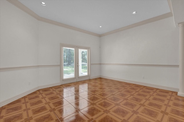 spare room featuring crown molding and decorative columns