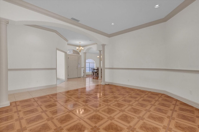 empty room with a notable chandelier, ornamental molding, and ornate columns