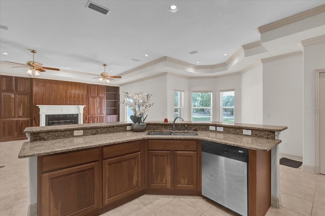 kitchen with sink, a center island with sink, a tray ceiling, light tile patterned flooring, and stainless steel dishwasher