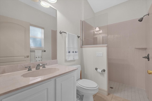 bathroom featuring vanity, toilet, tile patterned flooring, and a tile shower