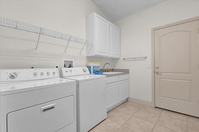 clothes washing area with cabinets, sink, light tile patterned floors, and washer and clothes dryer