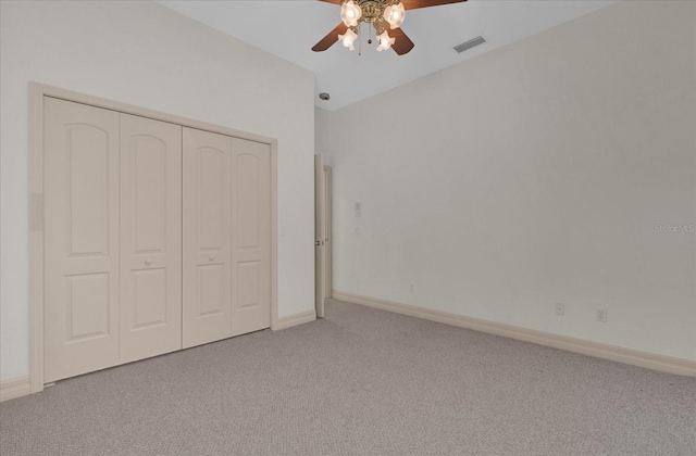 unfurnished bedroom with light colored carpet, ceiling fan, and a closet