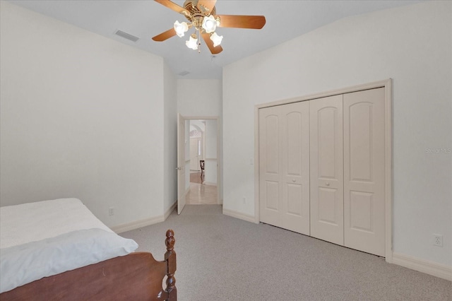 bedroom featuring lofted ceiling, light colored carpet, ceiling fan, and a closet