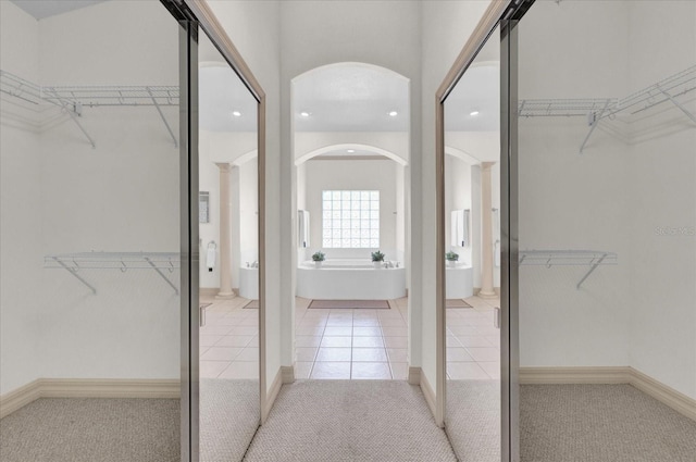 walk in closet featuring light colored carpet