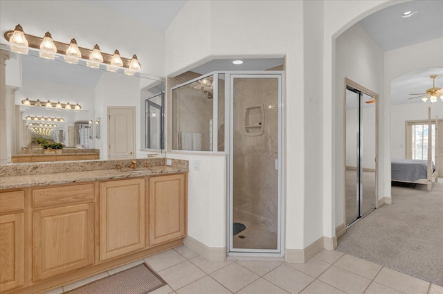 bathroom with ceiling fan, tile patterned floors, vanity, and a shower with shower door