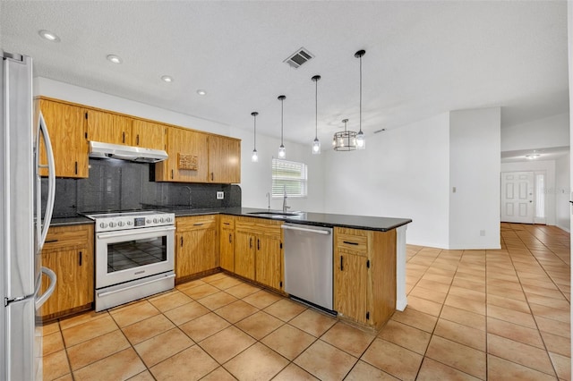 kitchen featuring sink, appliances with stainless steel finishes, kitchen peninsula, pendant lighting, and decorative backsplash