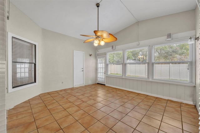 tiled empty room featuring lofted ceiling and ceiling fan