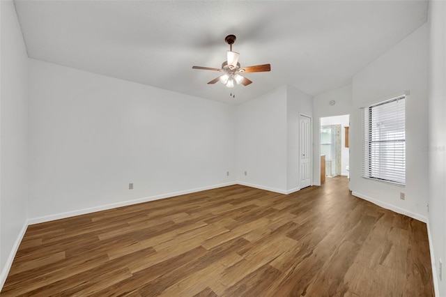 spare room with hardwood / wood-style flooring, lofted ceiling, and ceiling fan