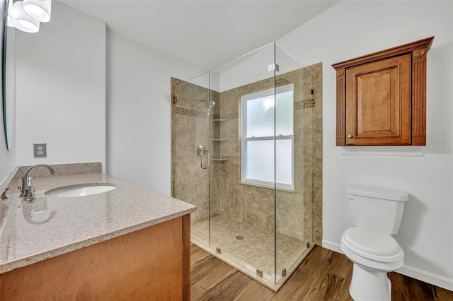 bathroom with vanity, toilet, a shower with door, and hardwood / wood-style floors