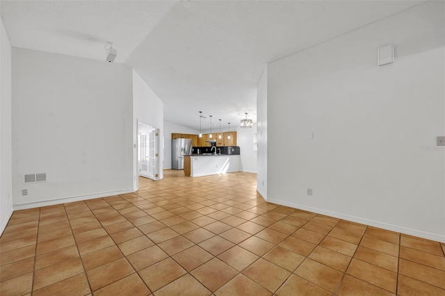 unfurnished living room featuring light tile patterned floors and vaulted ceiling