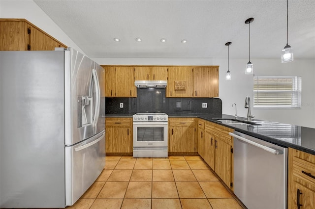 kitchen with sink, backsplash, stainless steel appliances, light tile patterned flooring, and decorative light fixtures