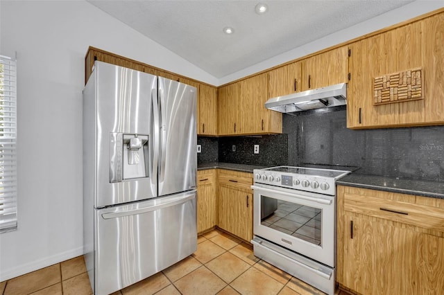 kitchen with lofted ceiling, backsplash, stainless steel appliances, and light tile patterned flooring