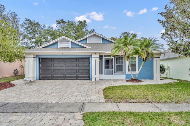 view of front of property featuring a garage and a front lawn