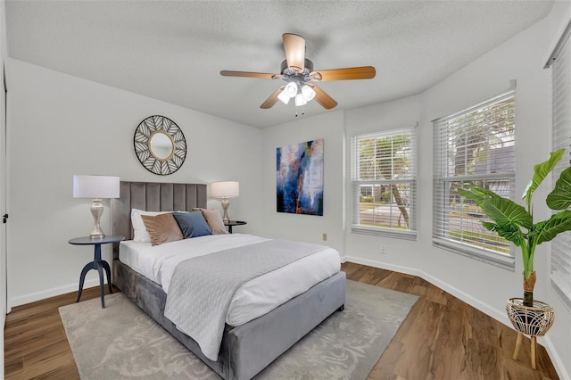 bedroom featuring hardwood / wood-style floors, a textured ceiling, and ceiling fan