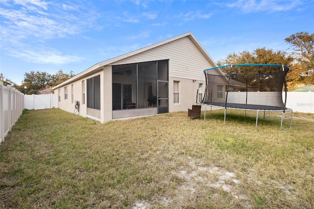 back of property with a sunroom and a yard