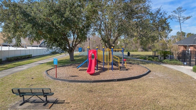 community playground featuring a yard and fence