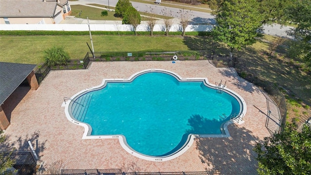 view of pool with a patio, a lawn, and fence