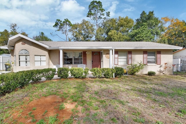 ranch-style home featuring a porch and a front lawn