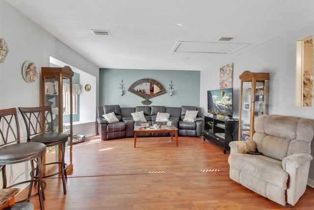 living room featuring light hardwood / wood-style floors and a textured ceiling