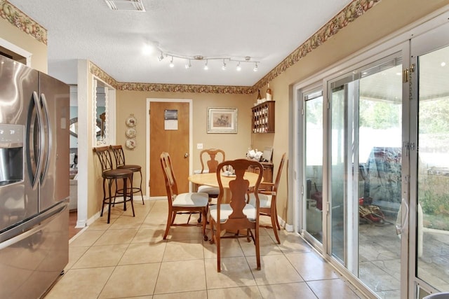 dining room with light tile patterned flooring and a textured ceiling