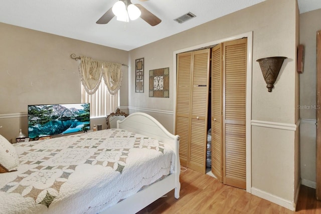 bedroom featuring hardwood / wood-style flooring, ceiling fan, and a closet